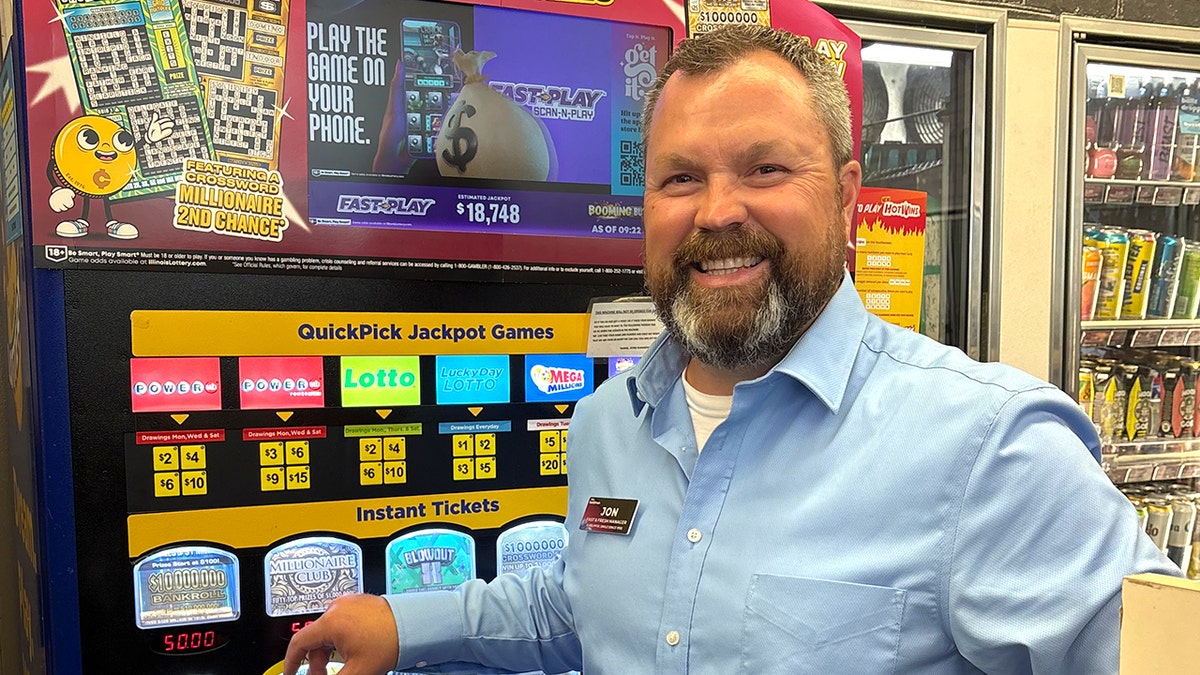 Jon Marshall standing next to Powerball machine