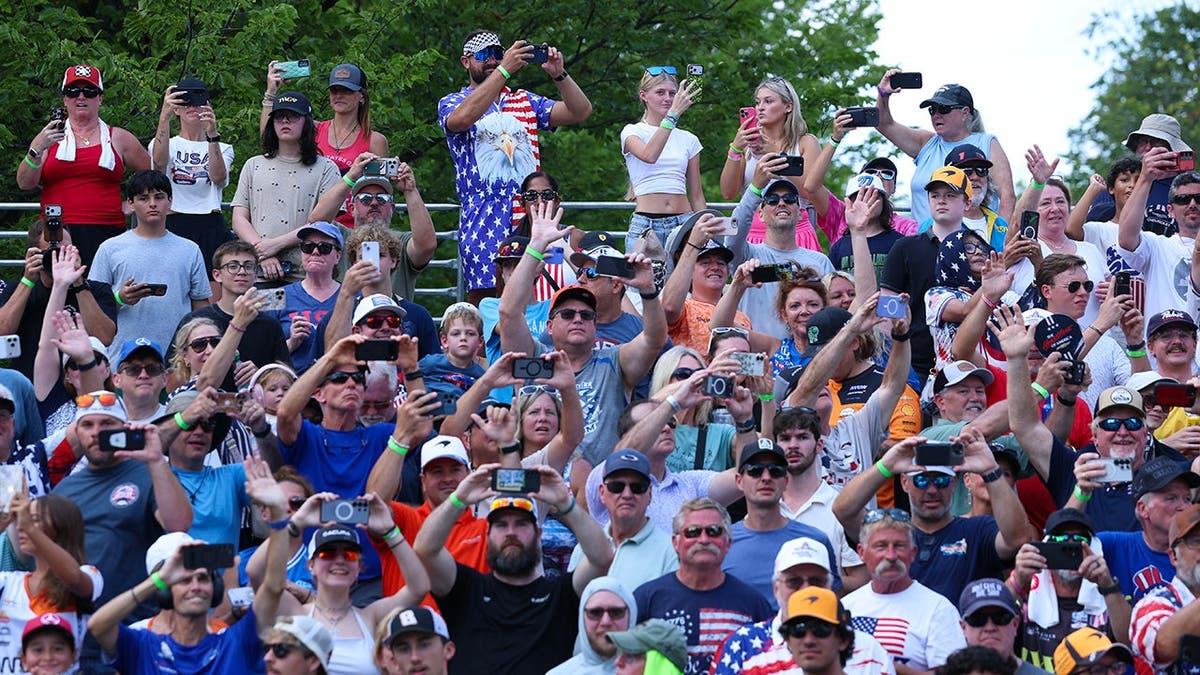Fans watch The Beast with President Donald Trump and first lady Melania Trump drive on the NTT INDYCAR Series track in Washington, D.C.