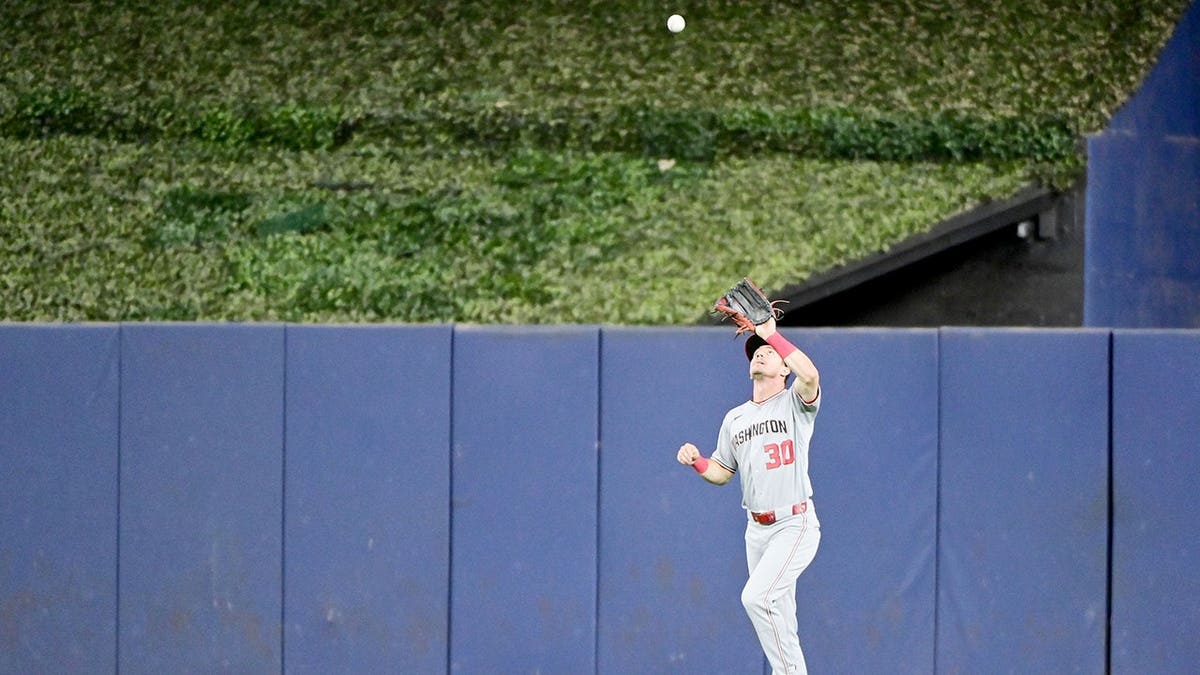 Jacob Young catches a fly ball during a baseball game in Miami.