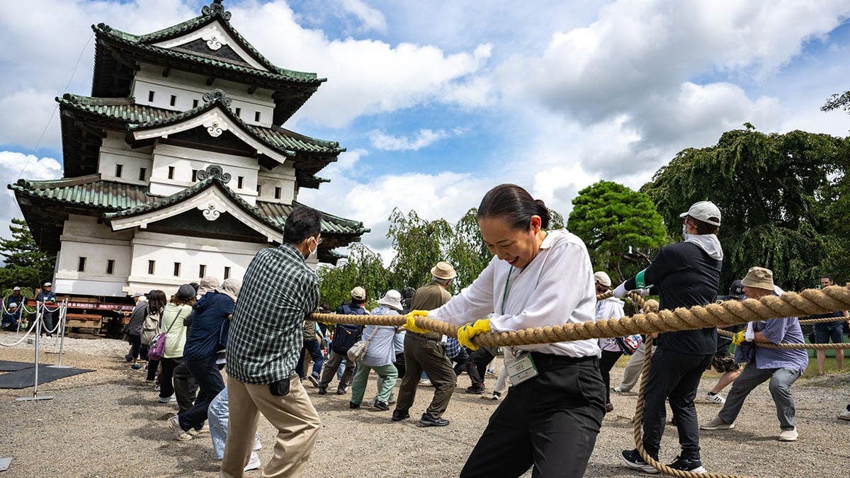 Participants pull Hirosaki Castle with ropes to its original position in Hirosaki, Aomori Prefecture.