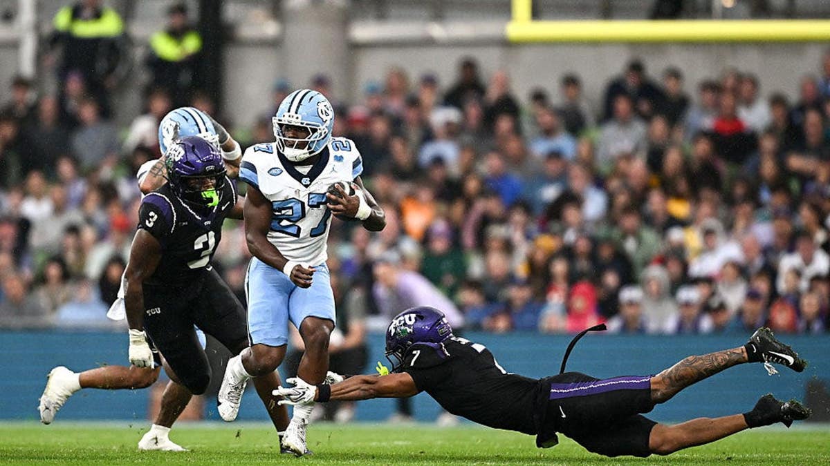 Jaylen McGill #27 evades tackle by Julius Simms #7 during college football game.