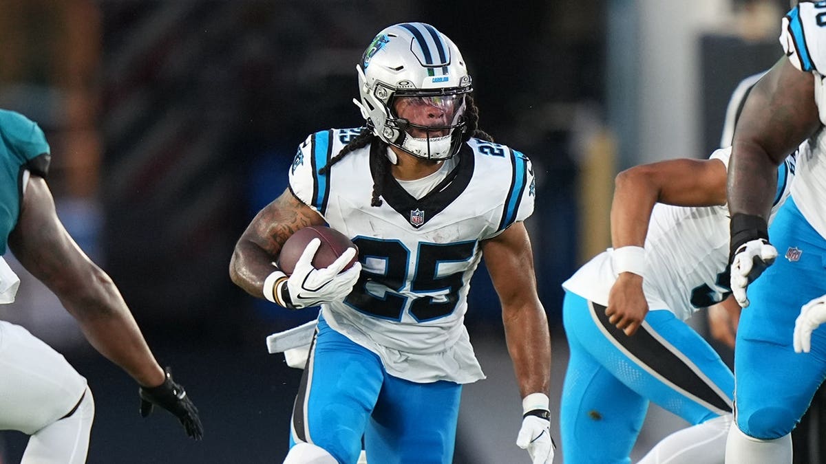 Jonathon Brooks rushes with the ball during an NFL preseason game.