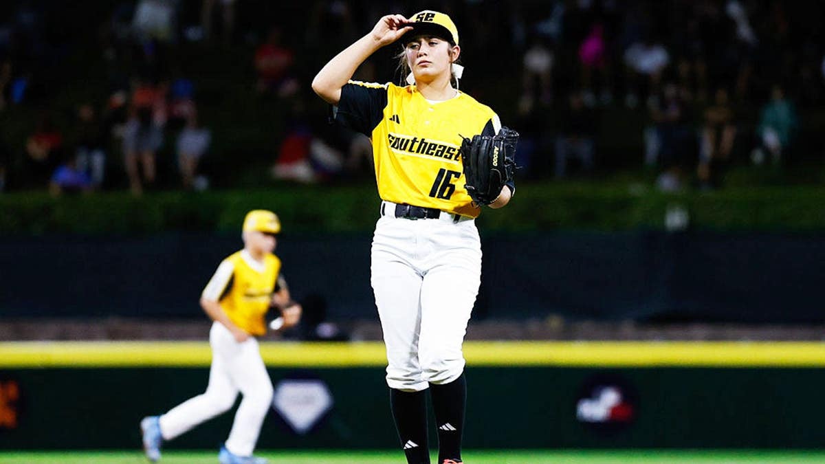 Kinley Rasmus adjusts her cap before pitching at a Little League World Series game.