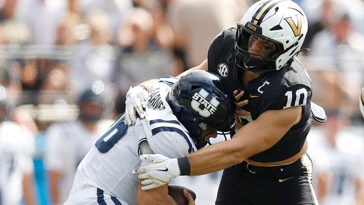 Langston Patterson #10 sacks Bryson Barnes #16 during a football game.