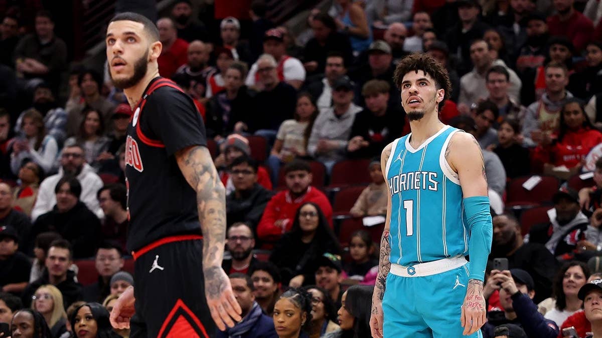 Lonzo Ball and LaMelo Ball look on during an NBA game at the United Center.
