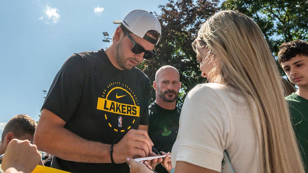 Luka Doncic signs an autograph for a fan during the Lakers' visit.