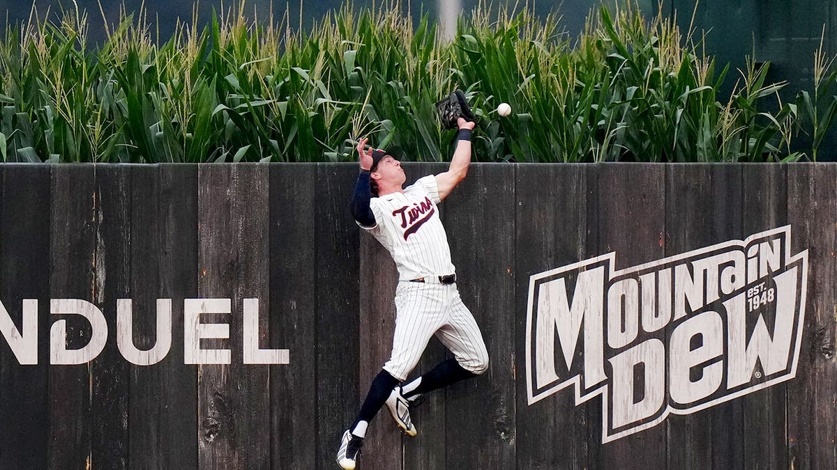Luke Keaschall of the Minnesota Twins reaches as Kyle Schwarber of the Philadelphia Phillies hits a home run.