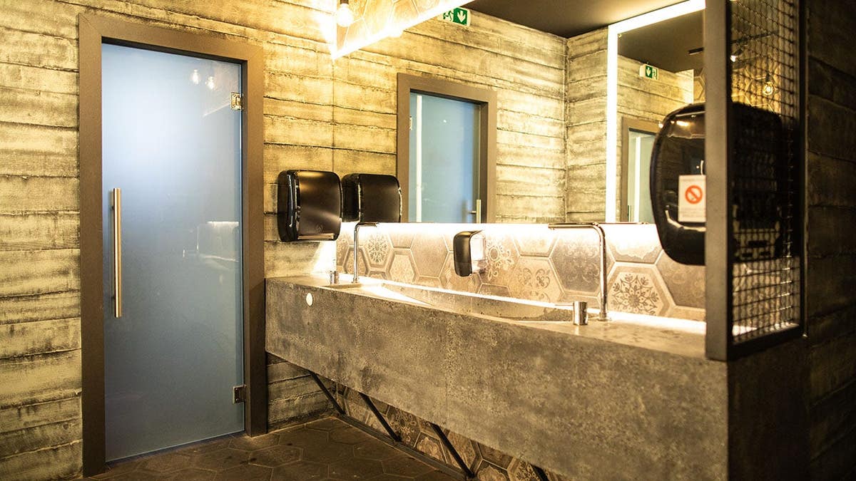 Luxurious bathroom with mirrors, door, and hand dryer