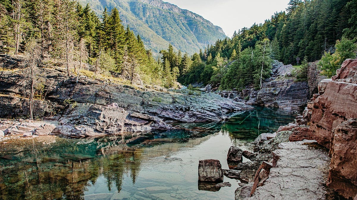 McDonald Creek reflects the rising sun in Glacier National Park.