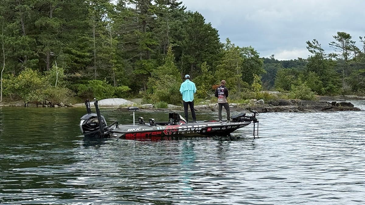Calvin Johnson and Brandon Palaniuk stand on a fishing boat