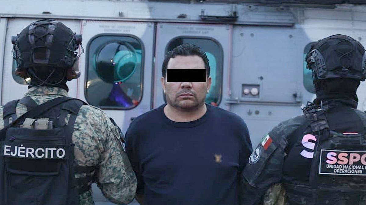 Ramón Ángel Álvarez Ayala stands with Mexican special security forces following his arrest.