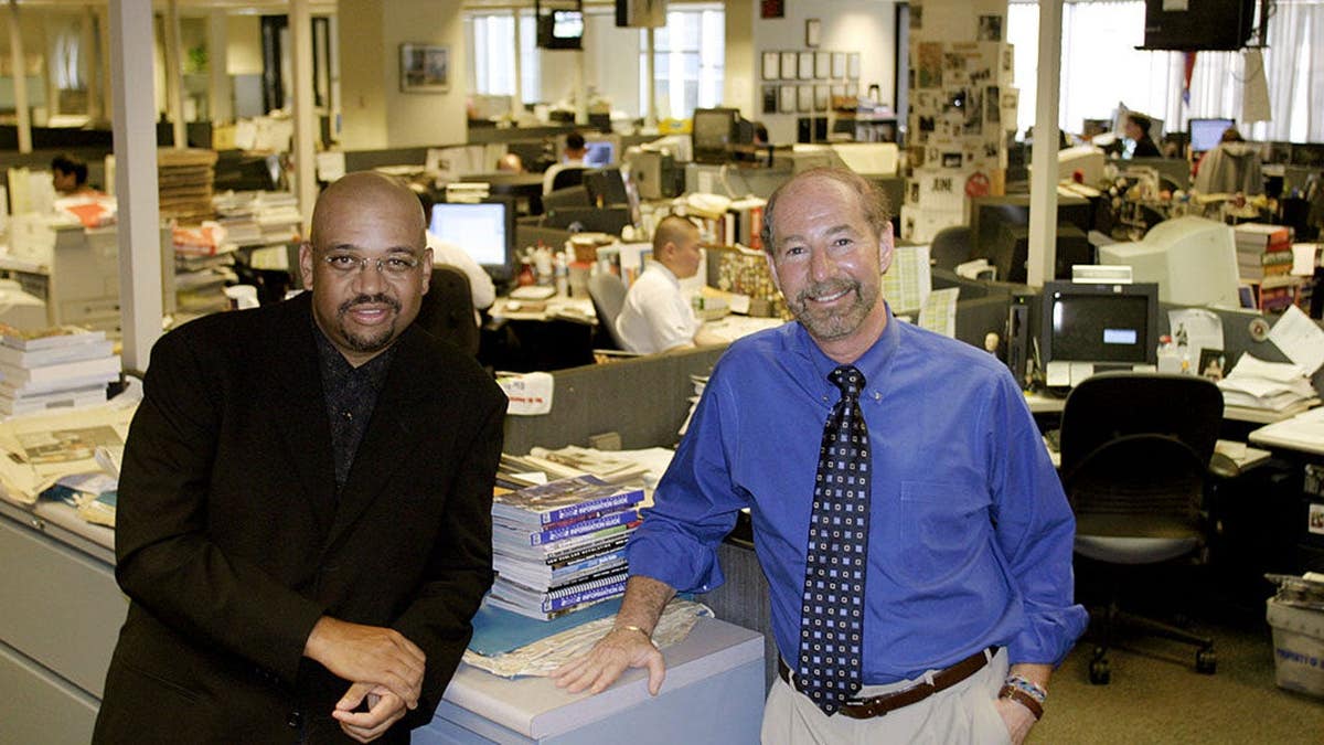 Michael Wilbon and Tony Kornheiser sit together in the Washington Post sports department.