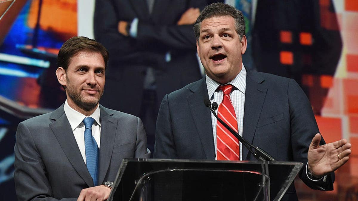 Mike Greenberg and Mike Golic speak at a podium during their Broadcasting Hall of Fame induction.