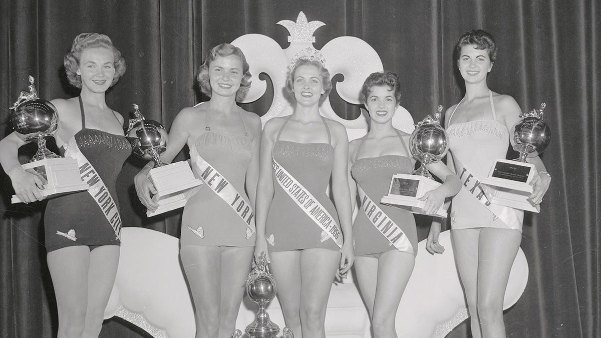 Mirian Stevenson and four other pageant winners hold trophies at the Miss U.S.A. division of the Miss Universe contest.