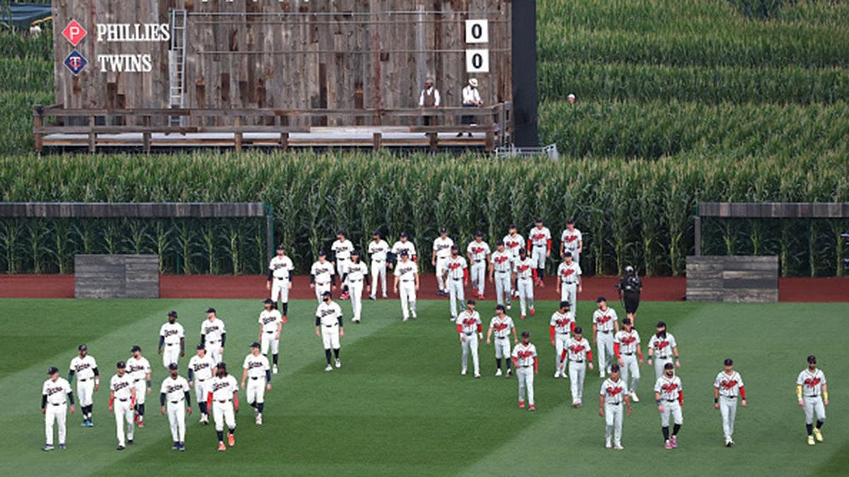 Philadelphia Phillies and Minnesota Twins players take the field before a game at Field of Dreams.