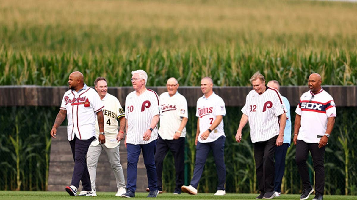 Former MLB players stand on the field before a game in Dyersville, Iowa.