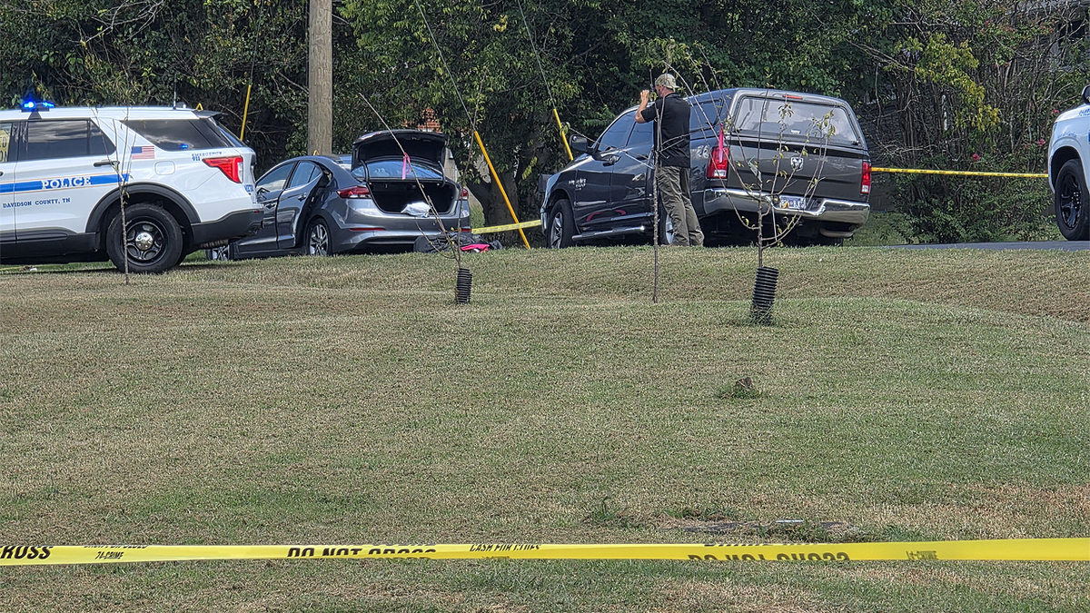 Police vehicles and crime scene tape near vehicles on Cheshire Drive in Nashville after a fatal officer-involved shooting
