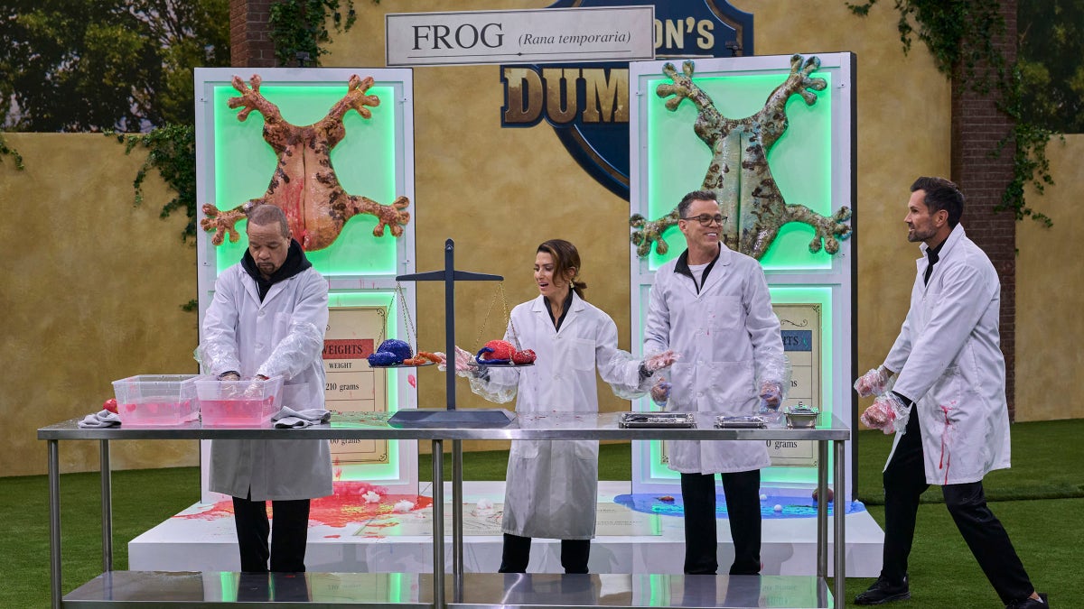 Ice-T, Hilaria Baldwin, Steve-O and Matt Leinart wearing lab coats around a table on a game show set.