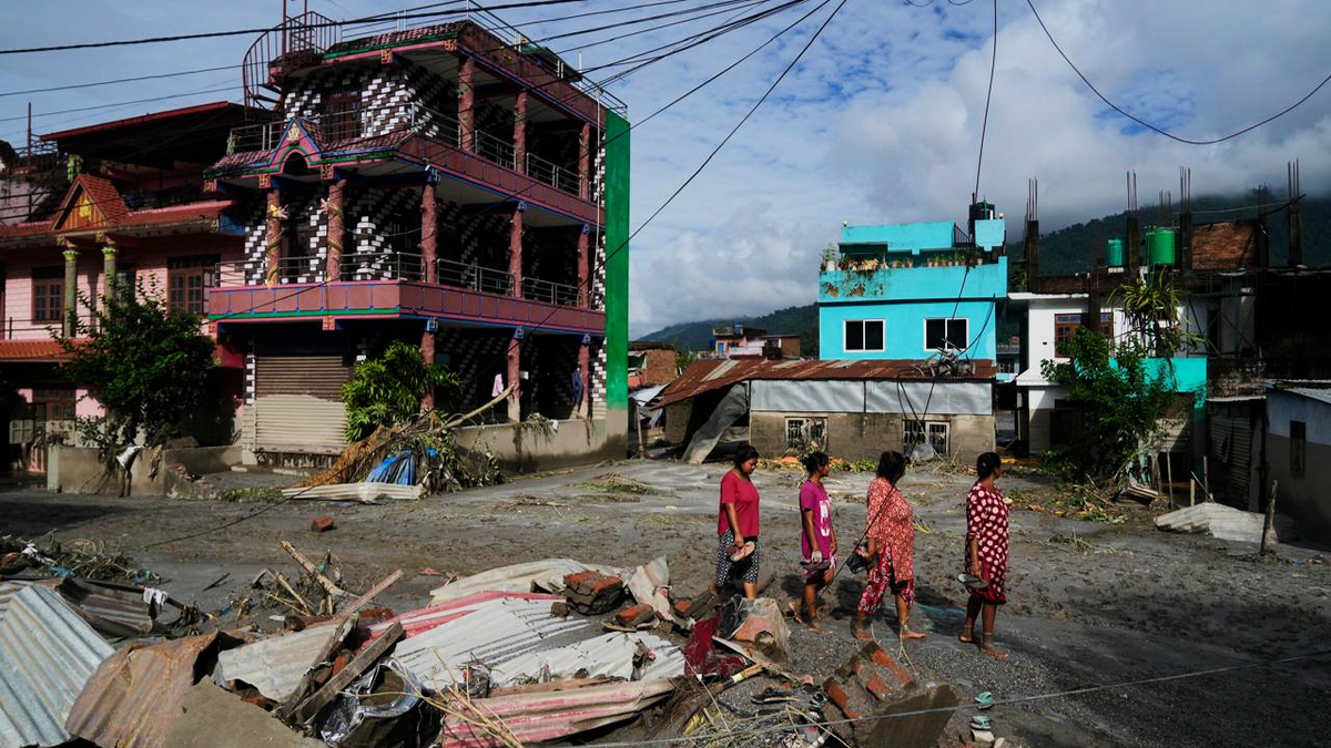People walk past damage in Nepal