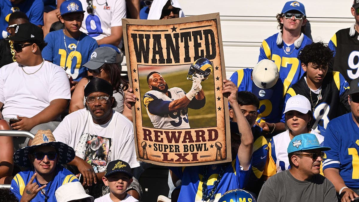 Los Angeles Rams fan holds a wanted poster for Aaron Donald during training camp.
