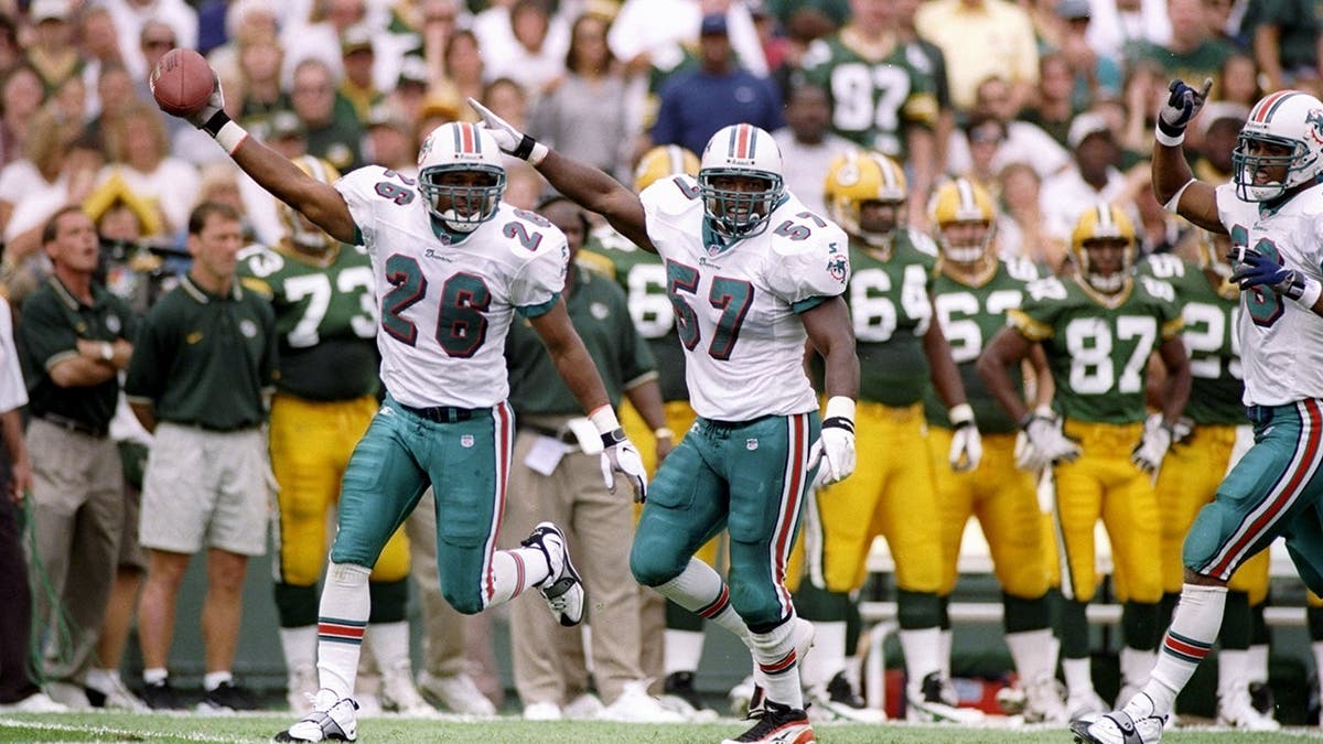 O.J. Brigance and Bracey Walker of the Miami Dolphins celebrate during a game at Lambeau Field.