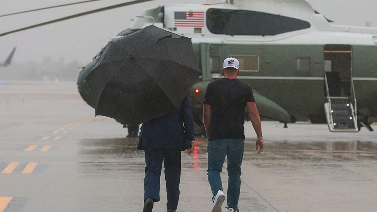 Pat McAfee walks toward Marine One with President Donald Trump at Cleveland Hopkins International Airport.