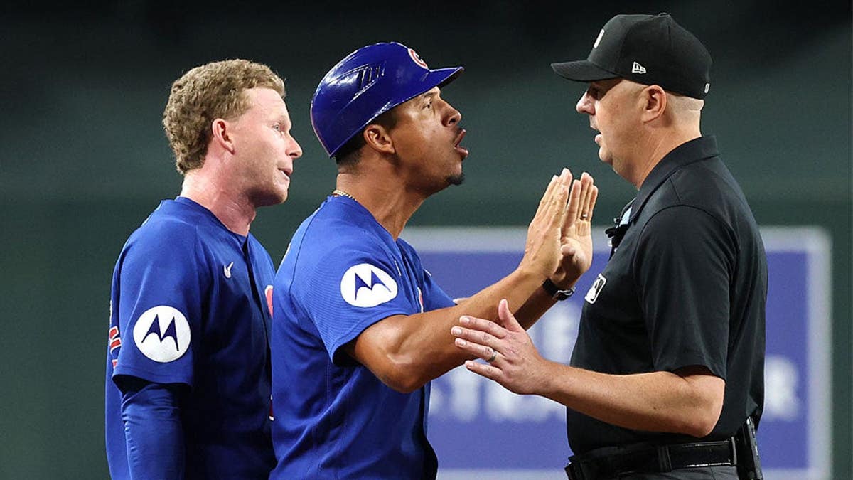 Pete Crow-Armstrong #4 and third base coach Quintin Berry #0 of the Chicago Cubs react at second base umpire Lance Barrett #16 during the sixth inning against the Arizona Diamondbacks at Chase Field on August 26, 2026 in Phoenix, Arizona.