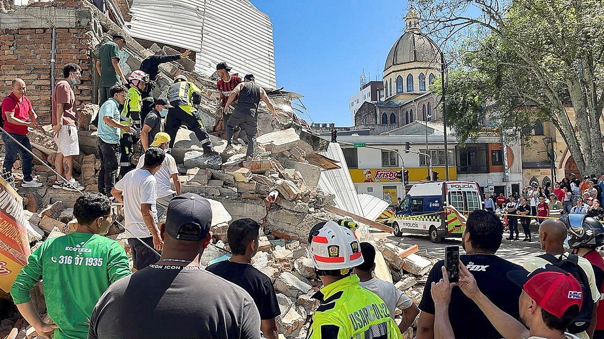Residents and emergency personnel dig through debris of a partially collapsed building in Pereira, Colombia.