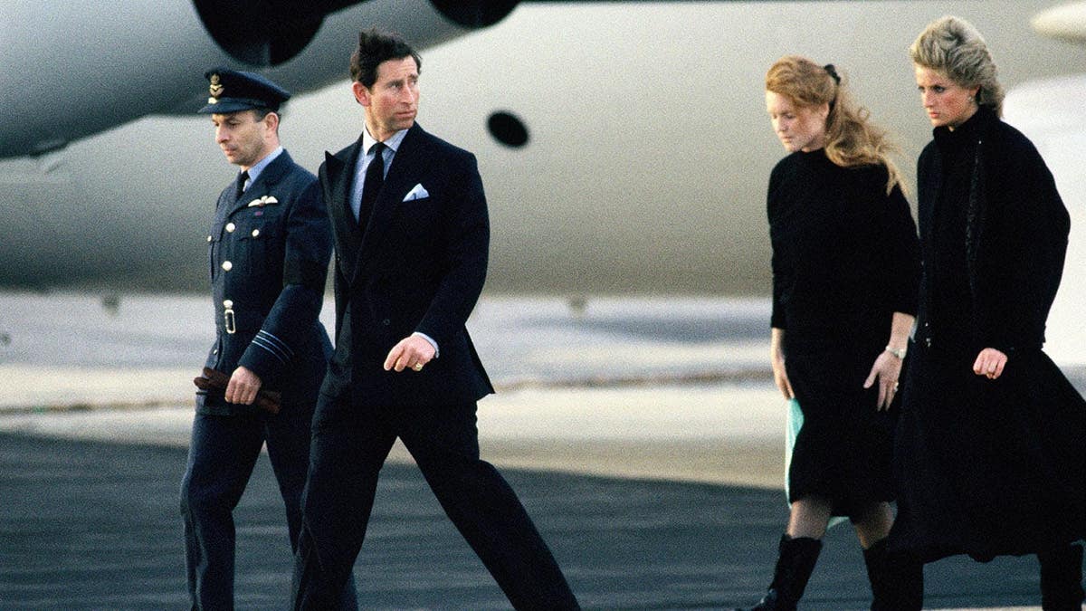 Prince Charles, Princess Diana and Sarah Ferguson stand near a coffin at RAF Northolt.