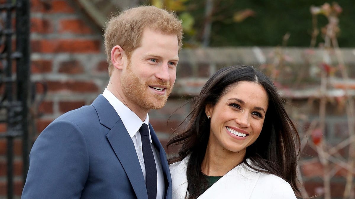 Prince Harry and Meghan Markle pose together during an engagement announcement photocall at Kensington Palace.