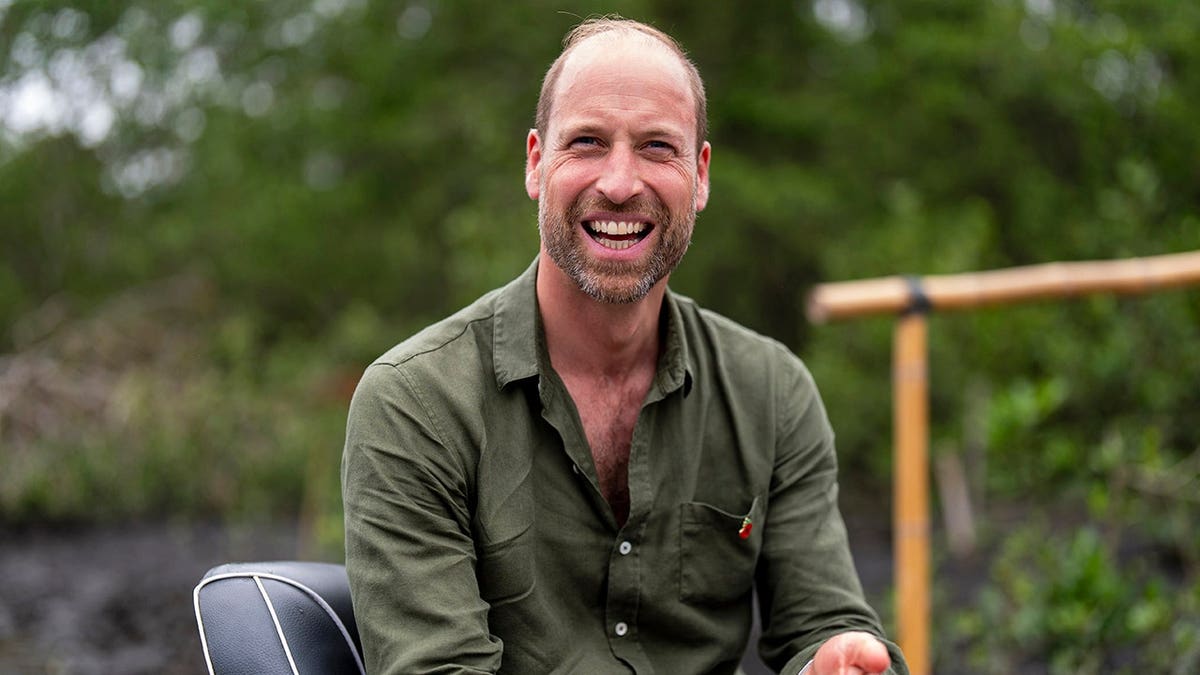 Prince William smiles while riding in a boat during a mangrove restoration tour in Guanabara Bay.