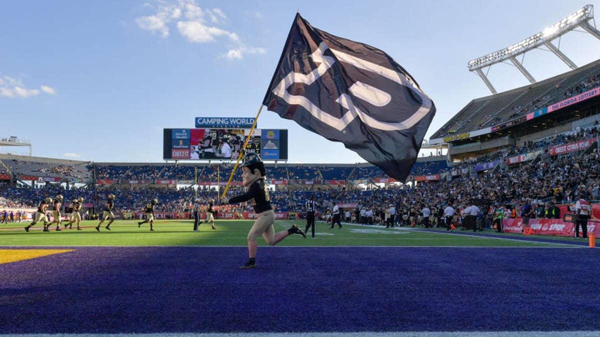 The Purdue mascot, Pete carries the Purdue flag