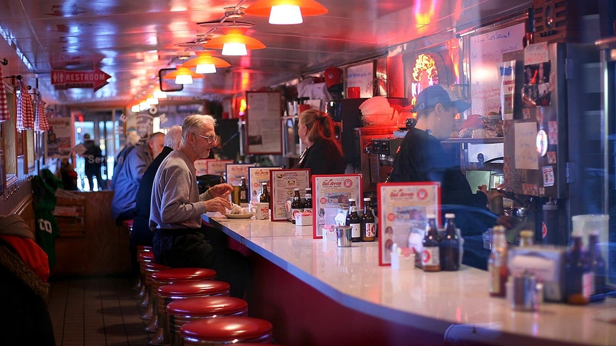 Customers sit at the counter of the Red Arrow Diner.