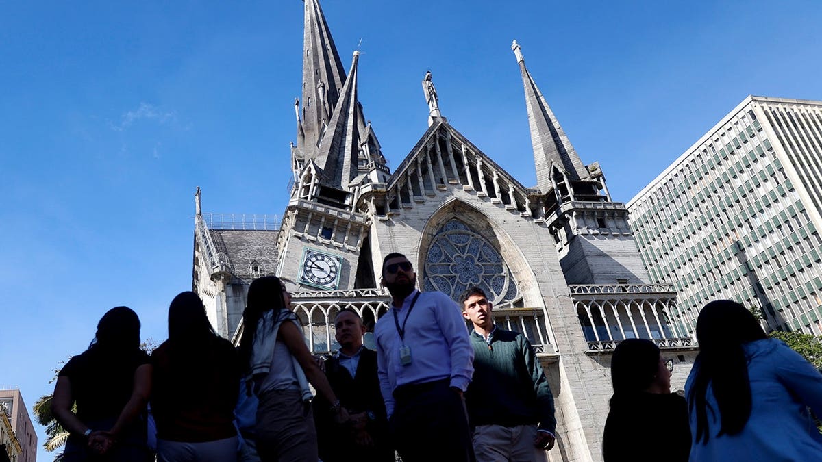 Residents stand outside the damaged Cathedral of Manizales after an earthquake.