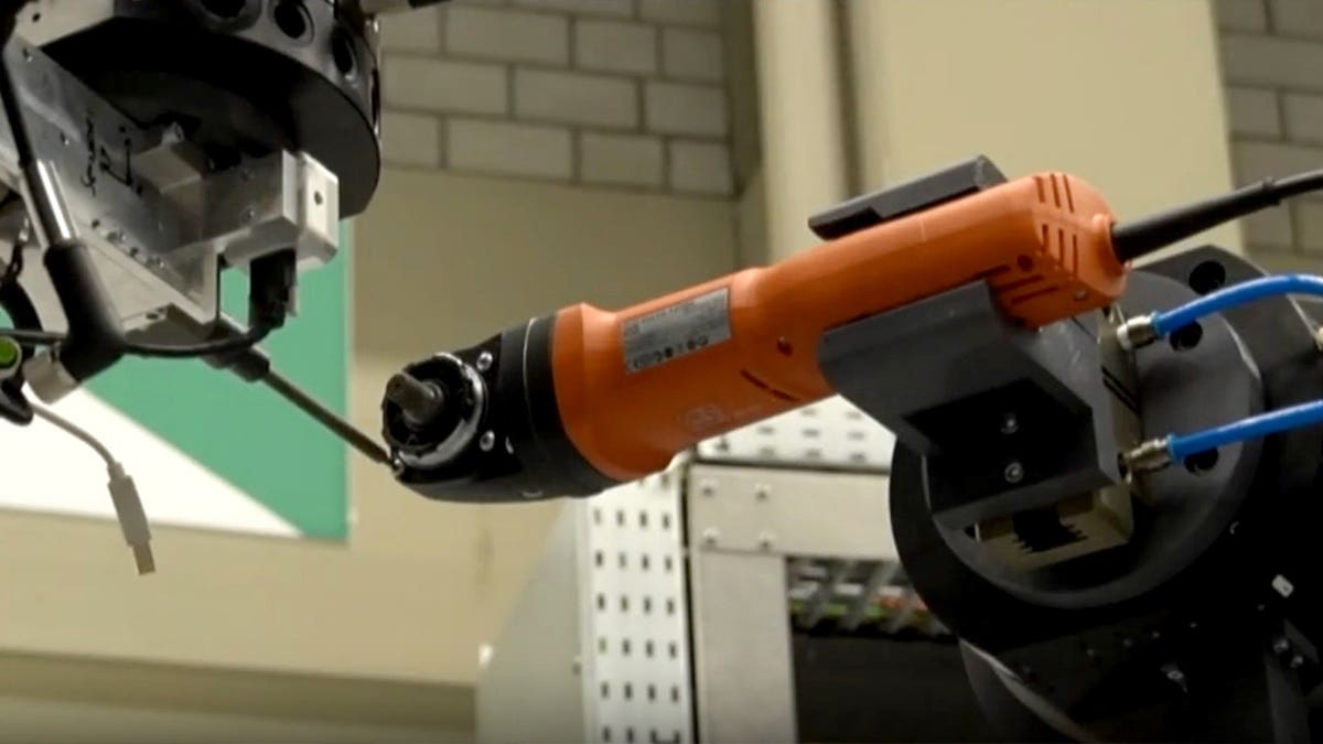 The robotic arm holds a tool.