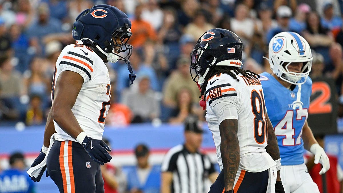 Roschon Johnson celebrates a touchdown with Zavion Thomas during a preseason NFL game.