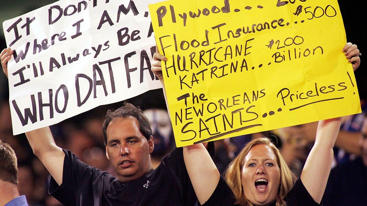 New Orleans Saints fans hold up signs at Giants Stadium during a game.