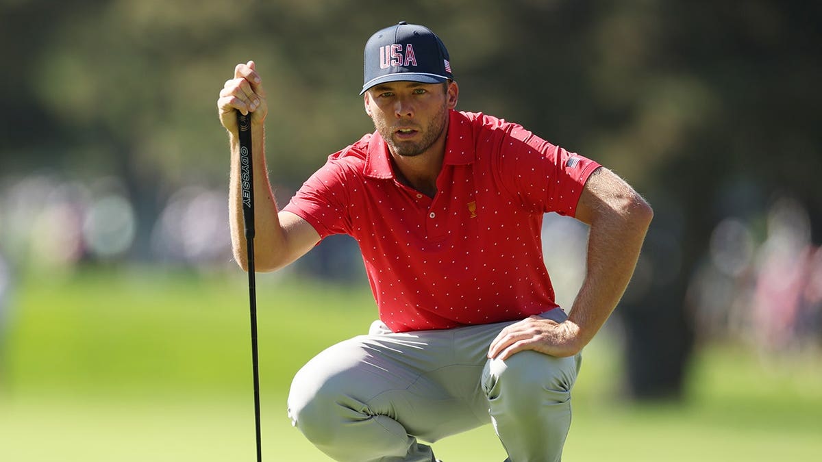 Sam Burns lines up a putt on the green.