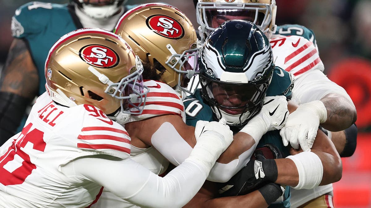 Saquon Barkley is tackled by 49ers defenders during an NFC Wild Card playoff game.