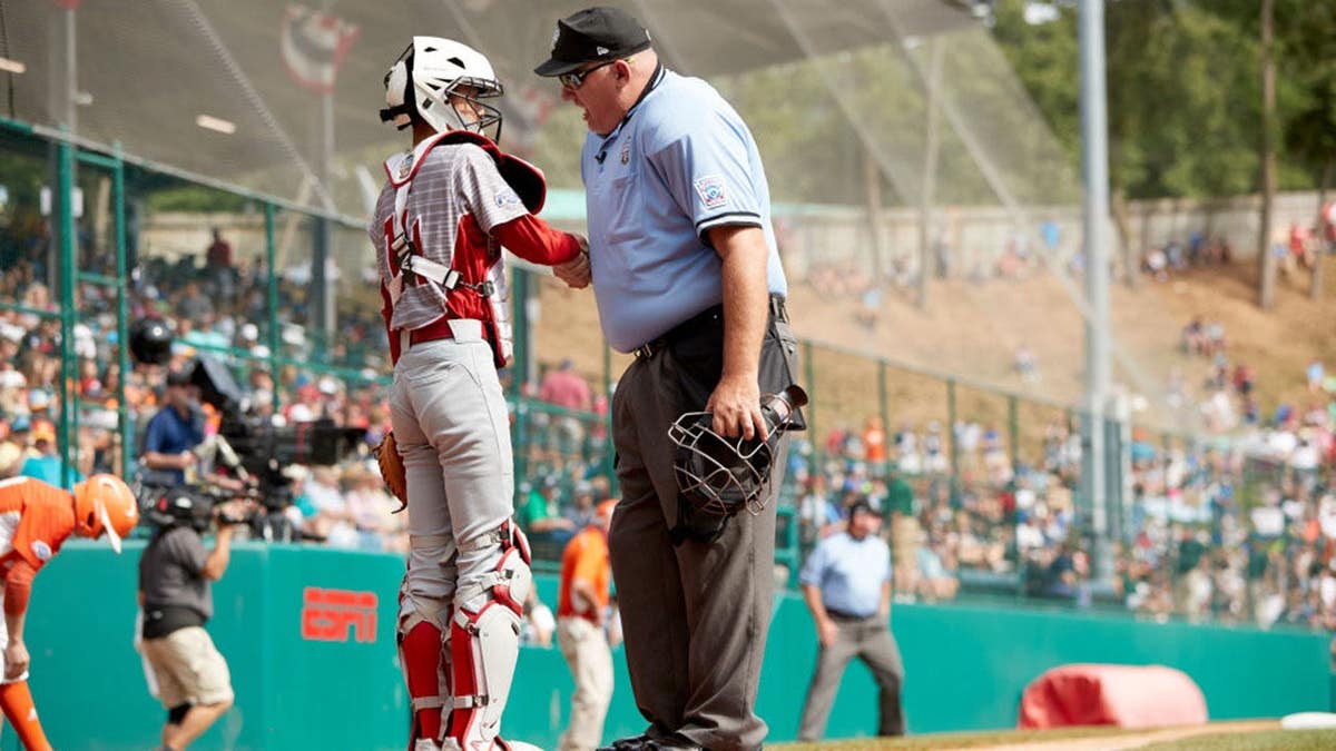 Seiya Arai shakes hands with an umpire during the Little League World Series championship game.