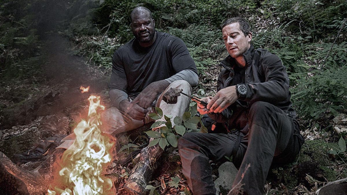 Shaquille O'Neal and Bear Grylls stand together.