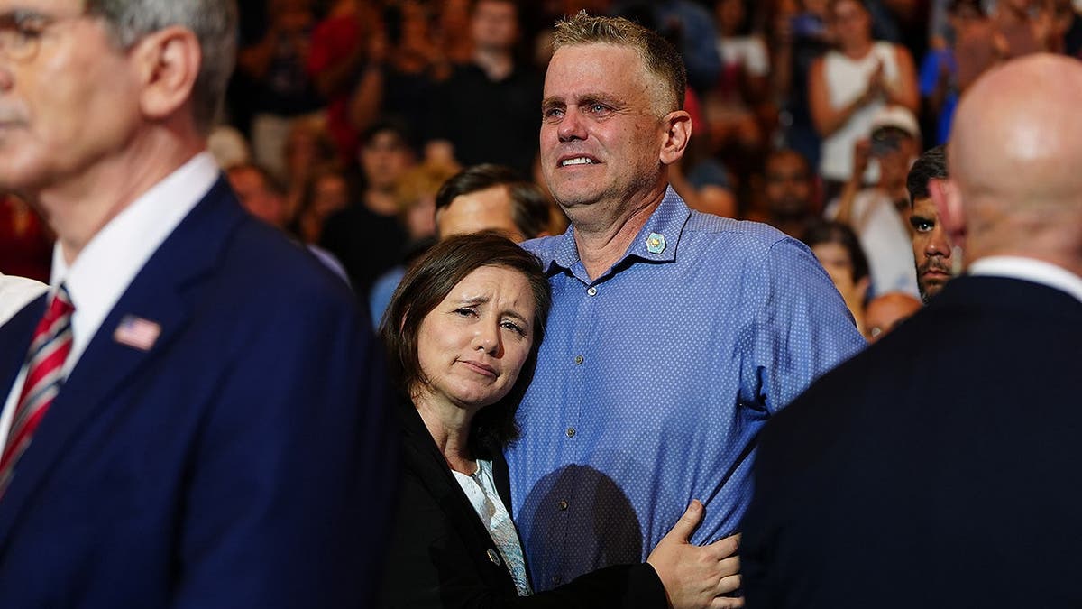 Shari and Stephen Feehan, parents of 1st Lt. Tyler James Feehan, react at Wheeler High School.