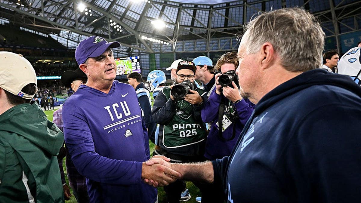 Sonny Dykes and Bill Belichick shake hands after a college football game in Dublin.
