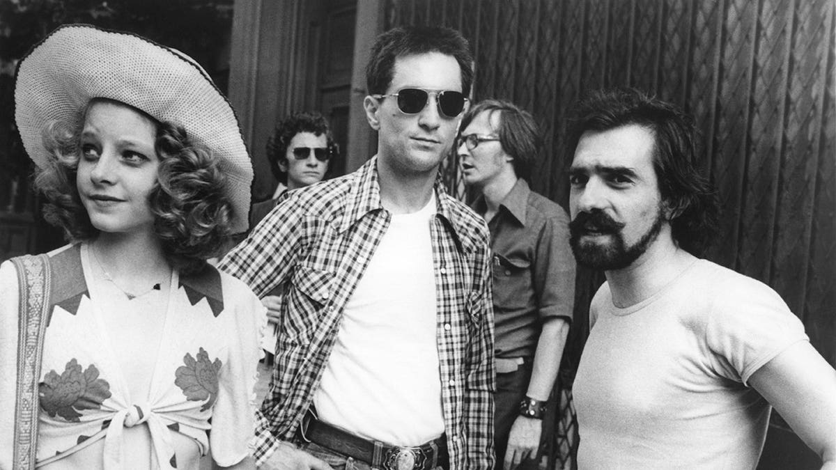 Jodie Foster and Robert de Niro stand with director Martin Scorsese on the Taxi Driver set.