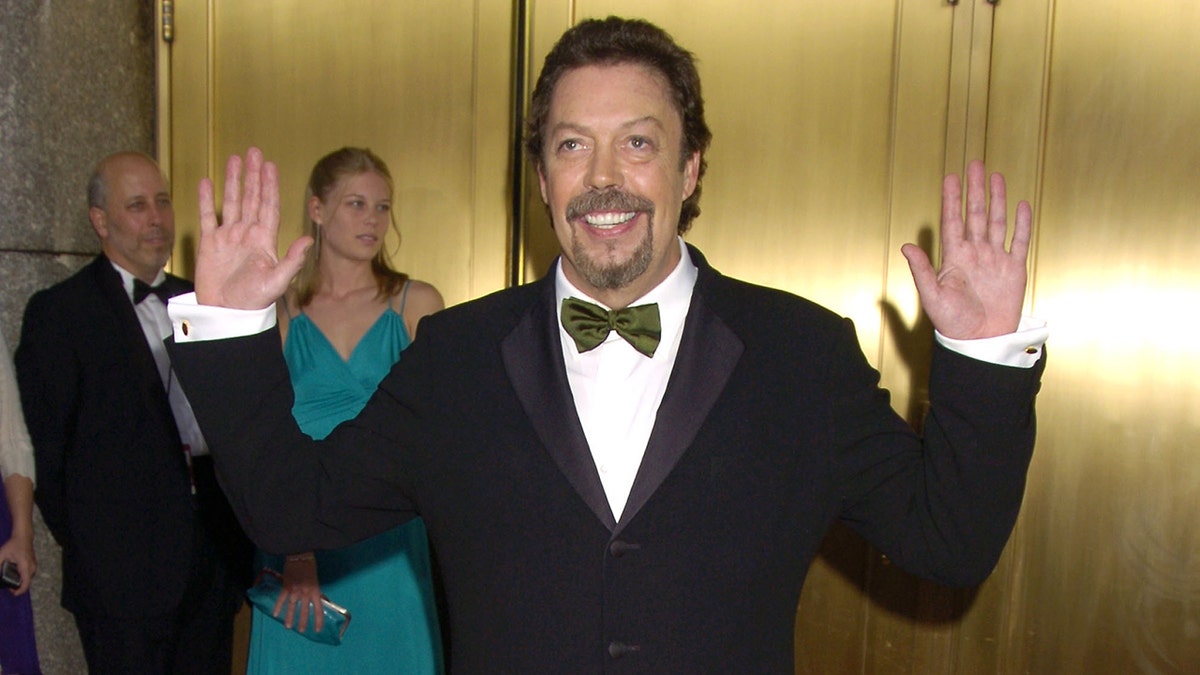 Tim Curry poses with his hands up outside the Tony Awards in 2005.