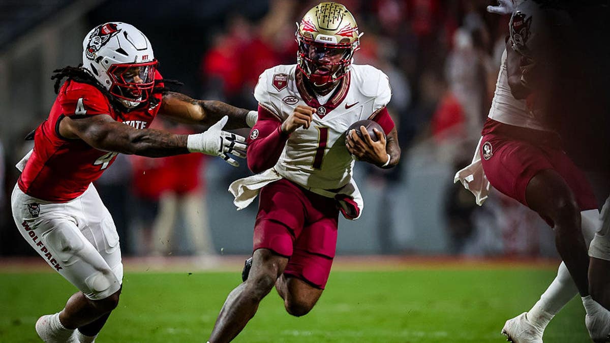 Tommy Castellanos evades a tackle by Tra Thomas during a football game in Raleigh, North Carolina.