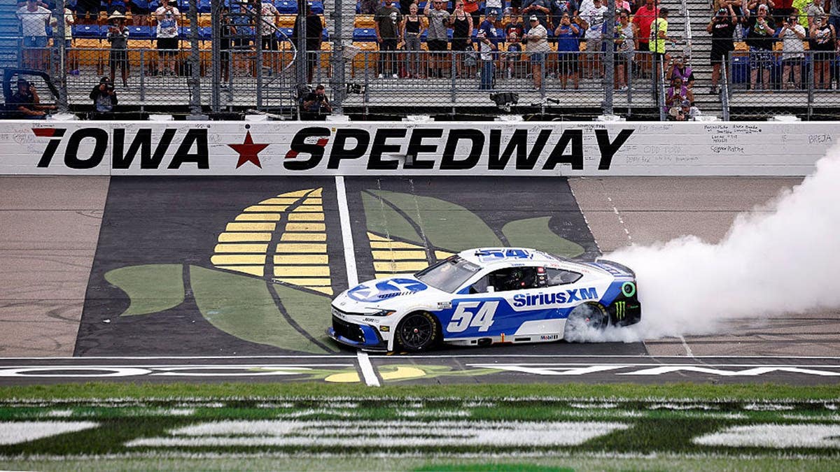 Ty Gibbs celebrates with a burnout after winning the NASCAR Cup Series Iowa Corn 350 at Iowa Speedway.