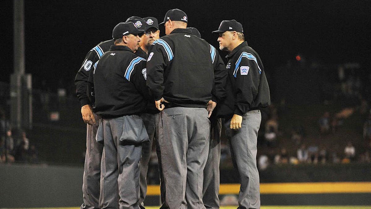 Umpires confer during a Little League World Series semifinal baseball game.