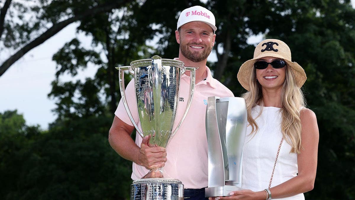 Wyndham Clark and Emily Tanner pose with championship trophies at Bellerive Country Club.