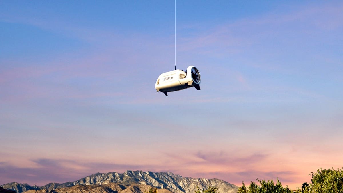 A delivery drone is lowered from a larger drone.